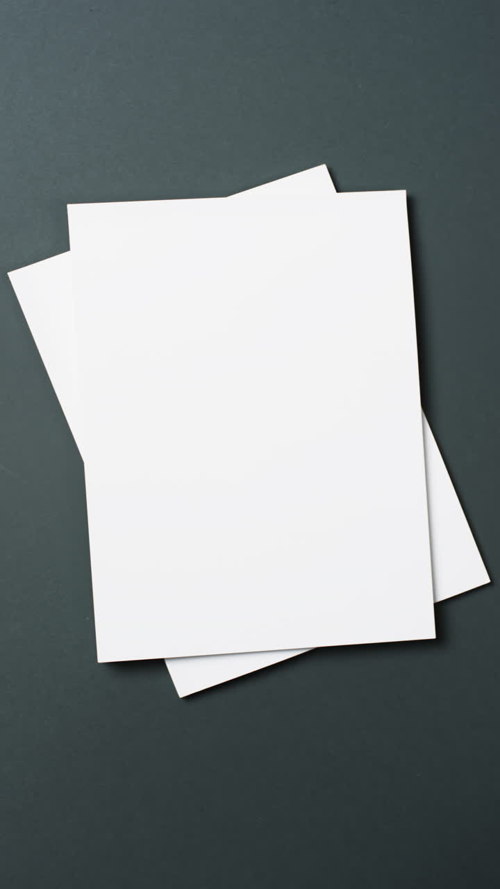 Vertical video of books with white blank pages and copy space on black background