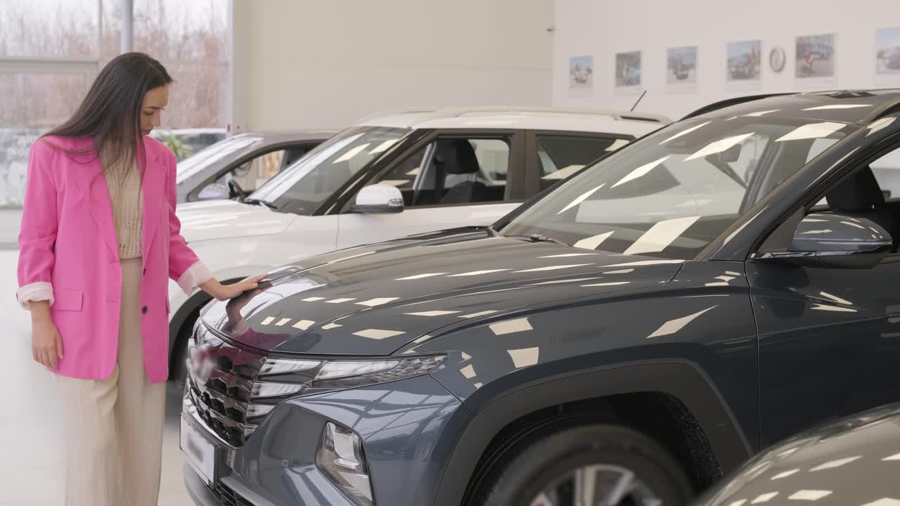 mujer eligiendo un coche en una sala de exposición de automóviles