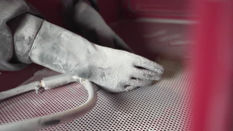 protective rubber gloves and blasting gun in a sandblasting cabinet