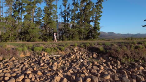 Tracking-shot-of-senior-couple-walking-on-rural-path