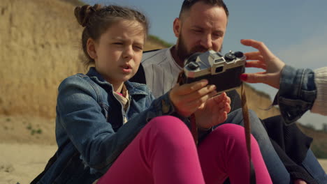 adorable girl taking photos on beach. child hold camera on family vacation trip.