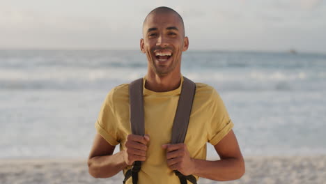 Retrato-De-Un-Joven-Alegre-En-La-Playa-Riéndose-Mirando-La-Cámara-Disfrutando-De-Una-Cálida-Aventura-De-Vacaciones-De-Verano-En-La-Hermosa-Costa-Del-Océano