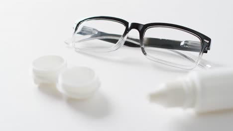 vídeo de gafas, caja de lentes de contacto y solución de lentes sobre fondo blanco con espacio para copiar