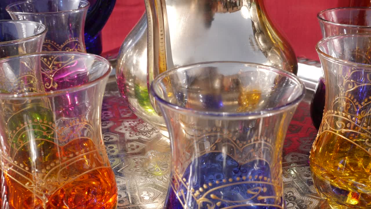 모로코 마라케시의 메디나에 있는 바자르에 있는 다채로운 전통 모로코 차 컵.