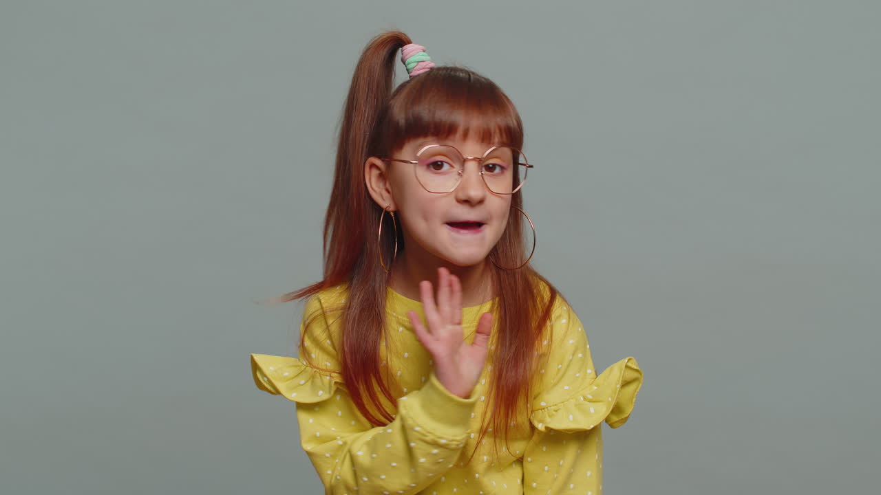 Preteen child girl presses finger to lips makes silence hush sign do not tells gossip secret quiet