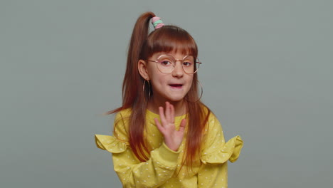 preteen child girl presses finger to lips makes silence hush sign do not tells gossip secret quiet