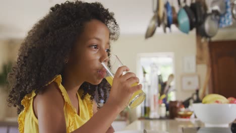 vista frontal de una chica afroamericana bebiendo jugo por la mañana