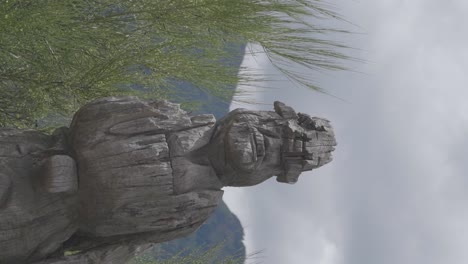 A-vintage-wood-carved-sculpture-statue-in-Patagonia,-Argentina-with-views-of-the-mountains-behind