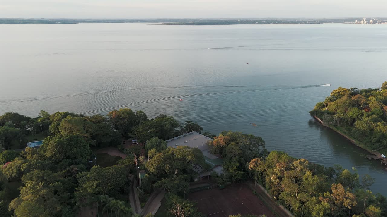 Ripresa aerea con drone in orbita sopra il fiume Paraná con una barca al centro.
