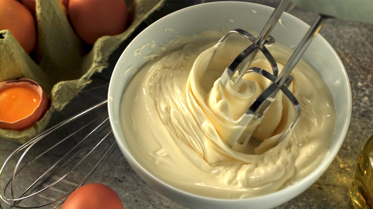 Electric Mixer Blending Creamy Mayonnaise in a White Bowl