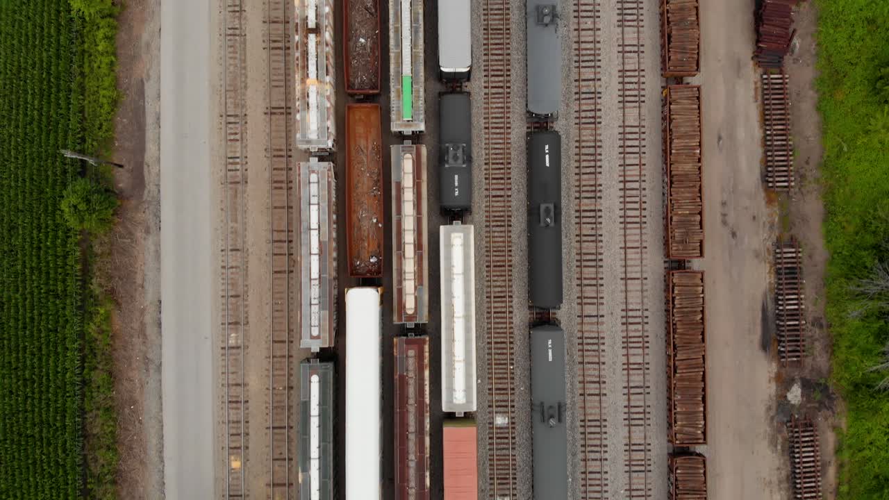 기차역에 주차되어 있는 동안 여러 열차를 보여주는 위에서 아래로 이동하는 4k 하향식 보기