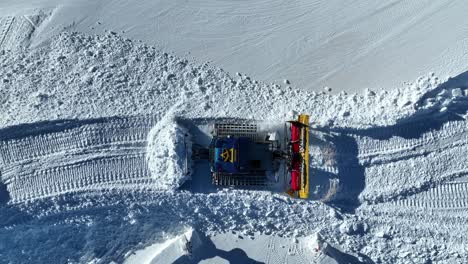 Top-Down-Aerial-View-of-Snow-Groomer-in-Ski-Resort,-Working-on-Sunny-Winter-Day