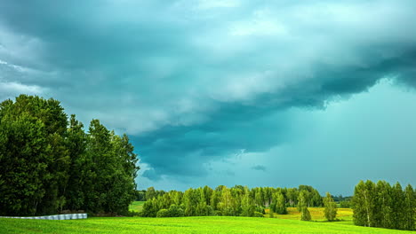 Zeitrafferaufnahme-Der-Wolkenbewegung-über-Grünem-Grasland,-Umgeben-Von-Bäumen-Entlang-Einer-Ländlichen-Landschaft-An-Einem-Bewölkten-Tag