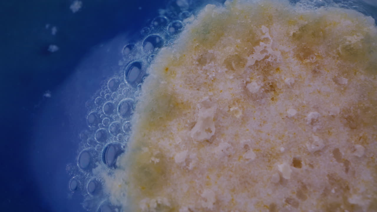 Close-up of a substance dissolving in liquid with bubbles