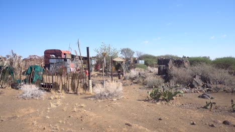 ancho de camping namibio con camión viejo, cercas y tierra seca con árboles contra un cielo azul