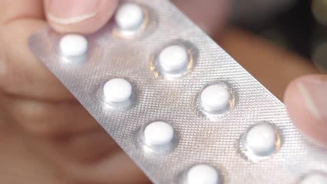 mano con un paquete de pastillas en blister