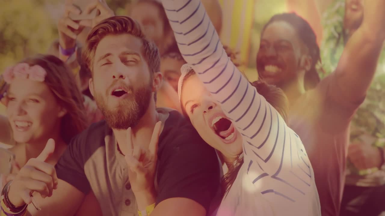 Front crowd cheering and filming on phone at music festival as performer cues, bokeh over faces