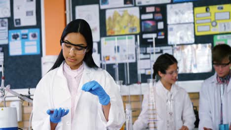 niña de escuela experimentando con productos químicos en el laboratorio de la escuela