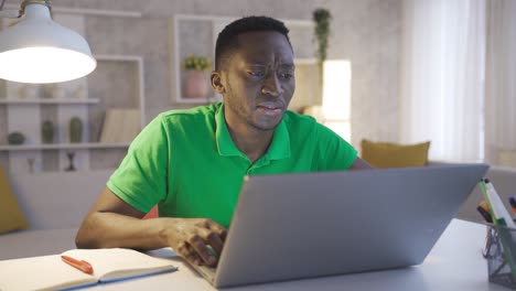 Thoughtful-serious-young-african-american-businessman-sitting-at-home-office-desk-with-laptop-thinking-solution-ideas