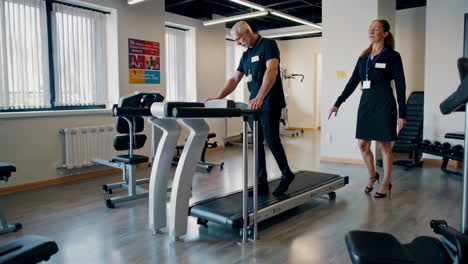 Physical Therapist Assisting Patient on Treadmill