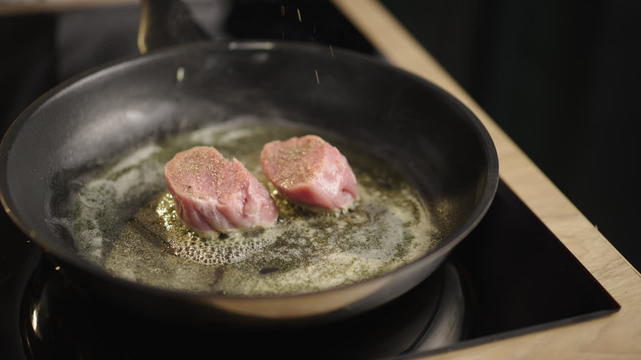 Pork being seasoned and fried in a pan