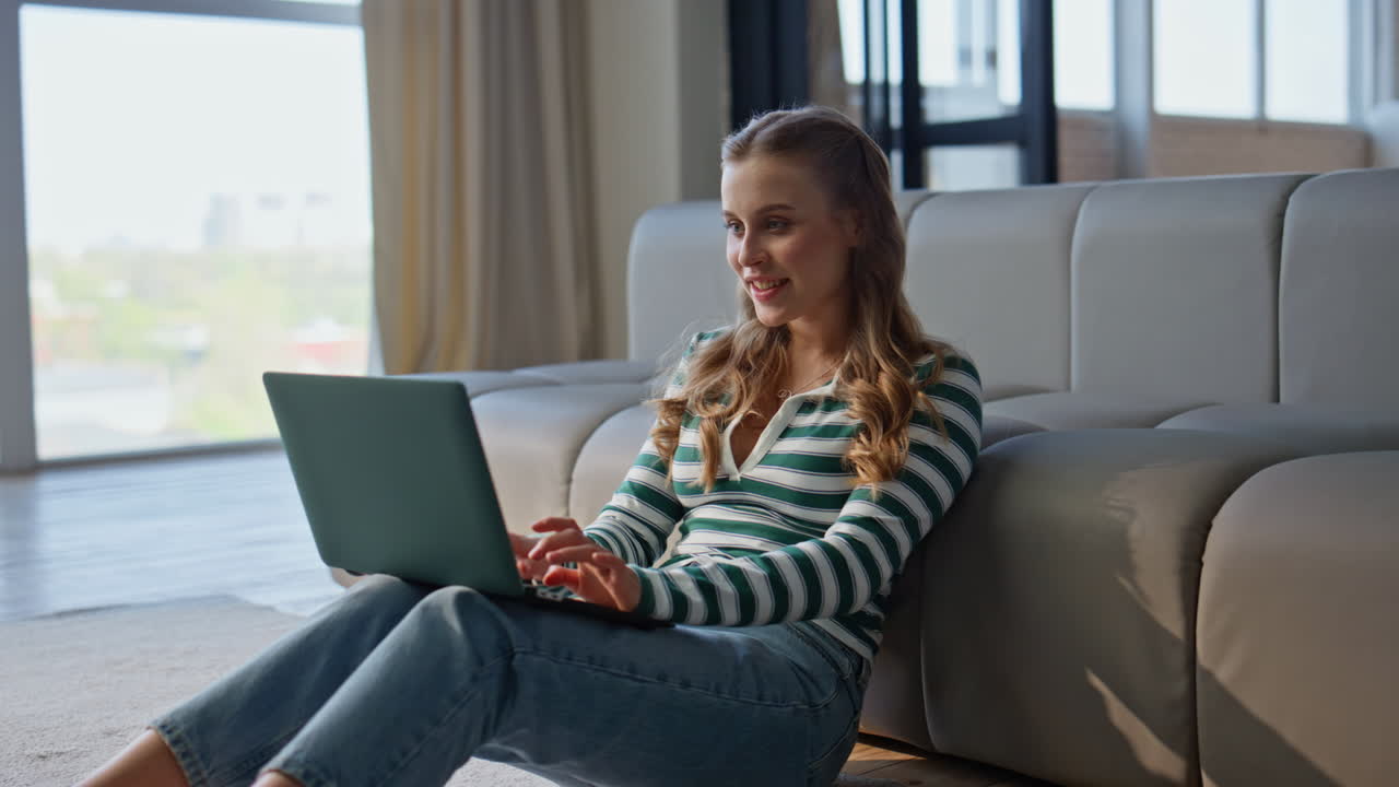 Pensive author working laptop in modern apartment. Serious woman typing computer