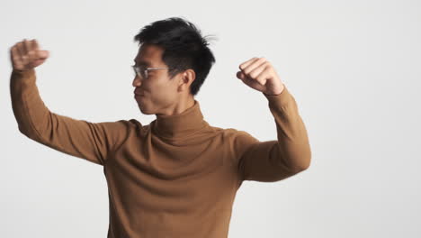 asian man dancing with closed eyes.