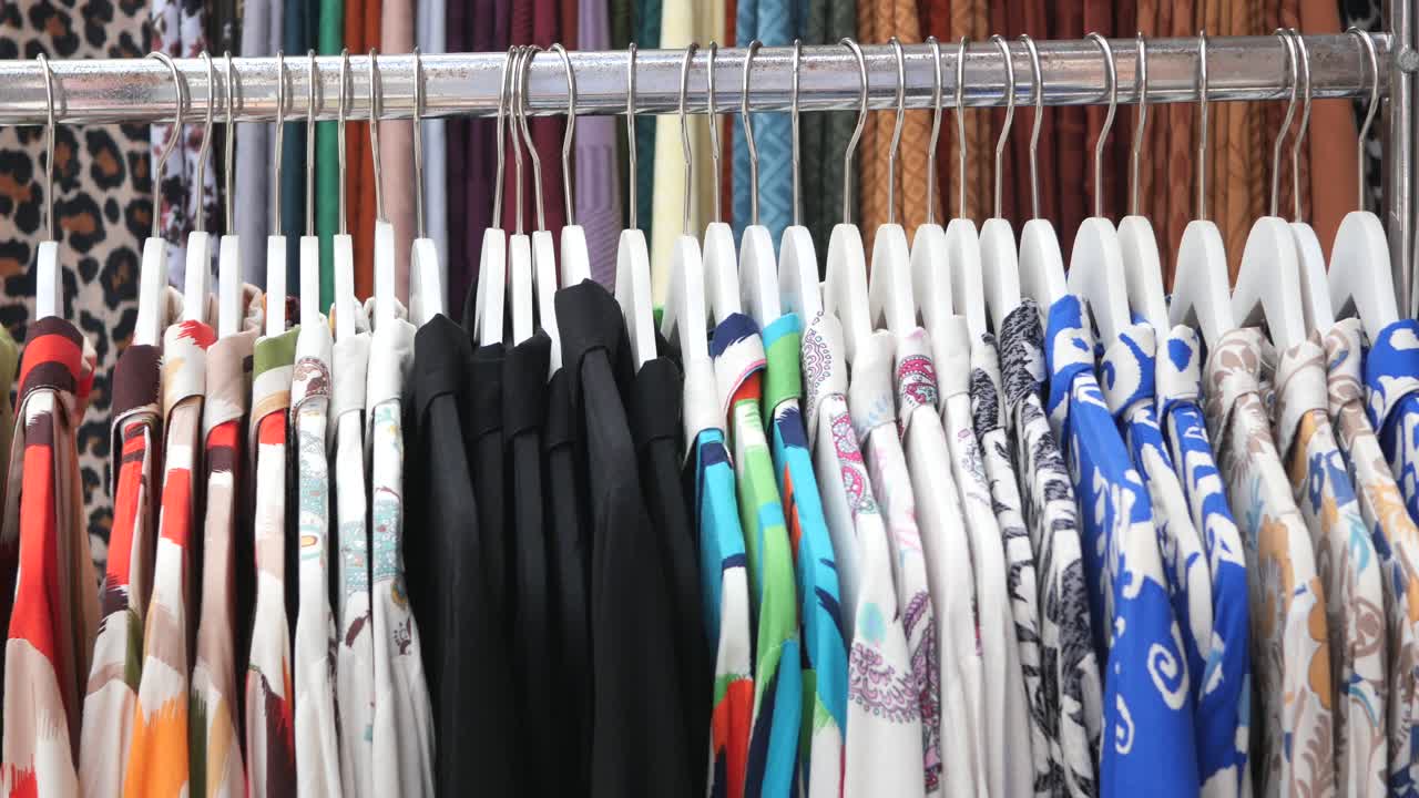 camisas coloridas en un estante en una tienda de ropa