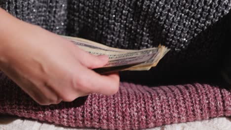 una mujer esconde dinero en un escondite entre la ropa