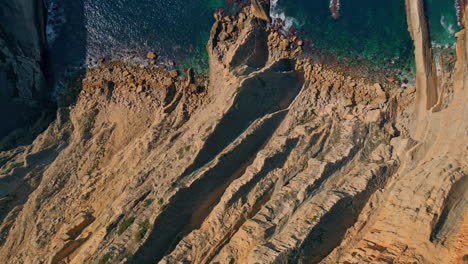 top stunning coastal rocks washed by clear waves summer day. blue ocean water