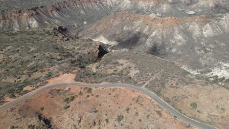 Drone-aerial-pan-down-over-the-road-of-the-Charles-knife-gorge-with-the-landscape-and-clouds