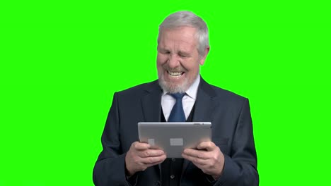un anciano empresario gracioso jugando en una tableta de pc.
