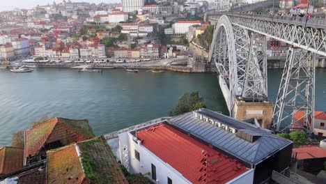 tomada inclinada del puente de porto y luis i con personas cruzando el río duero de día