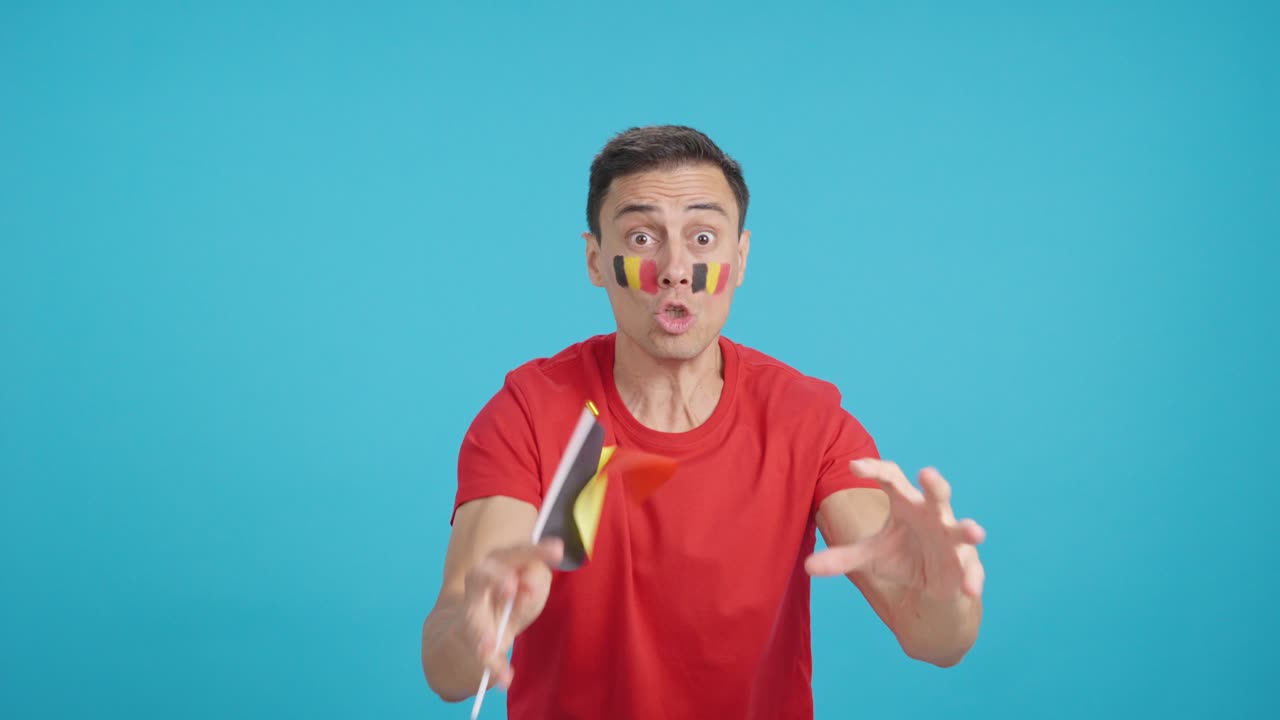 Man cheering for Belgium screaming and waving a national flag