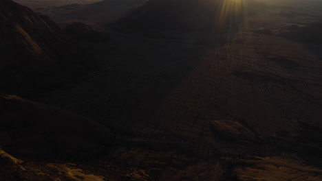 la inclinación aérea revela una la hora dorada del sol por encima de las montañas rocosas del desierto en áfrica