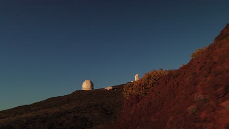 an astronomical observatory under a blue sky in a volcanic island