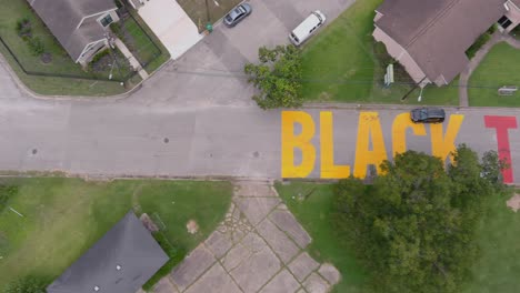 vista de pájaro de un gran cartel de &quot;las ciudades negras importan&quot; pintado en la calle en el histórico distrito de alturas de la independencia de houston