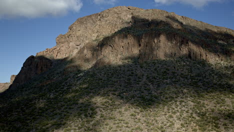 drone shot flying over cacti covered landscape with dramatic cloud shadows racing across valley floor