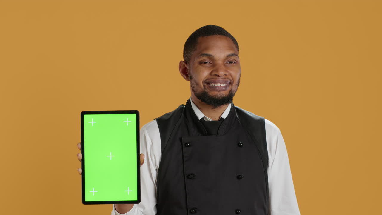 camarero profesional con delantal que presenta la tableta con una maqueta aislada