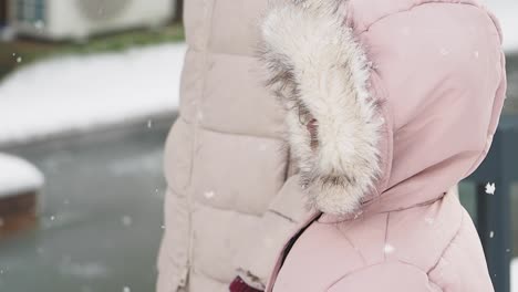 child in pink jacket in the snow