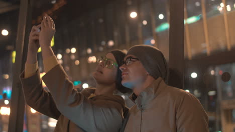 amigos jóvenes tomando selfies con el celular en la ciudad de la noche