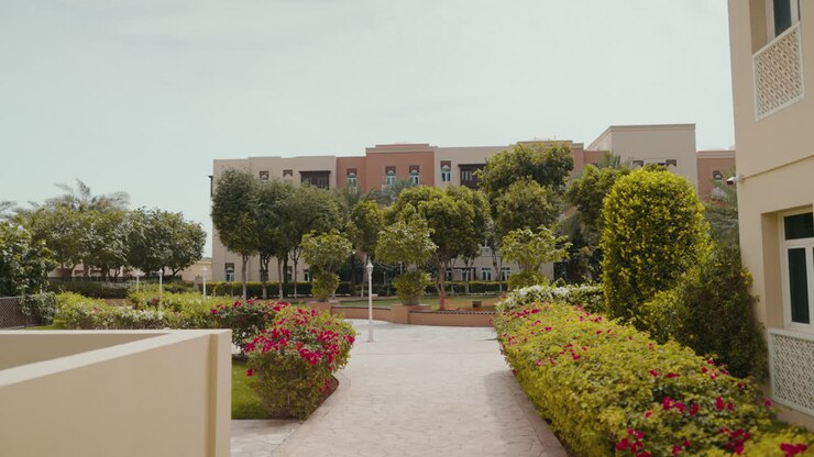 Esplora una casa nella comunità di Al Furjan, Dubai, circondata da una vegetazione lussureggiante, alberi e fiori vivaci, che evidenzia un ambiente residenziale sereno