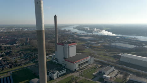 Flying-past-tall-chimneys-of-power-generator-on-a-large-industrial-terrain