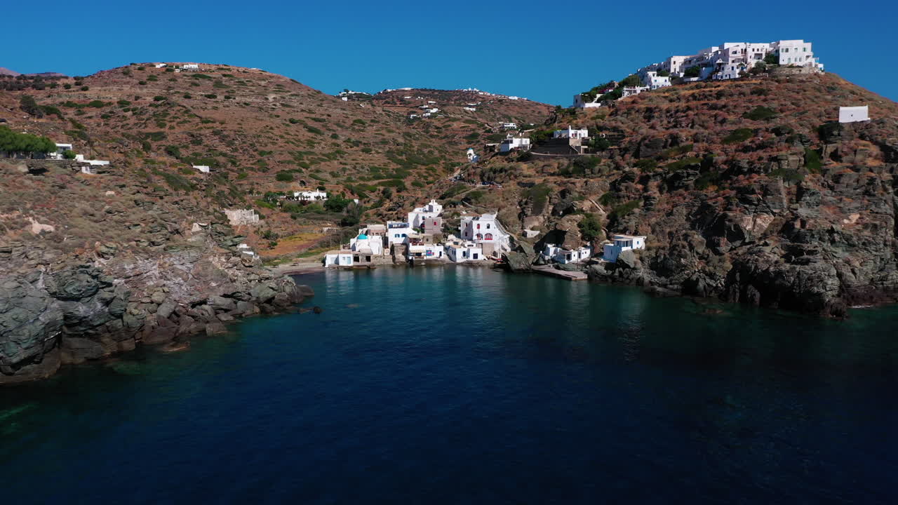 Aerial approach of a small cove and fishing village on the cycladic island of Sifnos, Greece.
