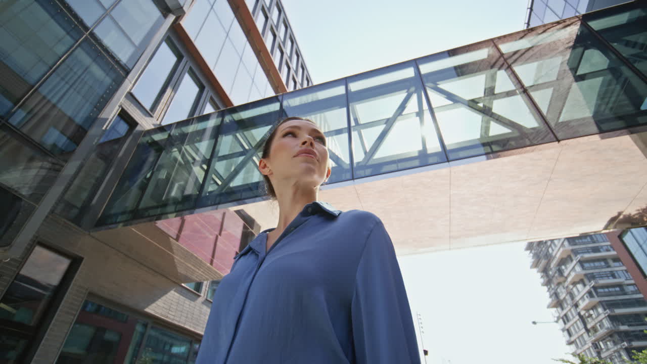 mujer rica de pie distrito de la ciudad vista de abajo de cerca. mujer de negocios exitosa