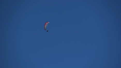 un paracaídas multicolor vuela en el cielo azul sobre los alpes suizos, obwalden