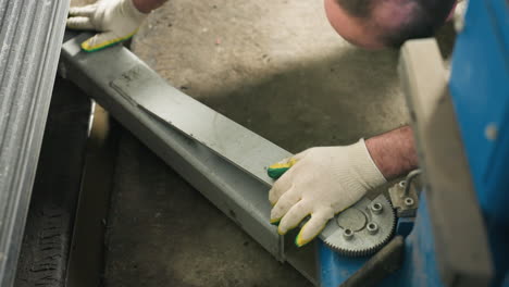 close-up of an engineer's hand placing a car lift under a vehicle in an auto repair shop, showcasing detailed mechanical work and safety equipment in use