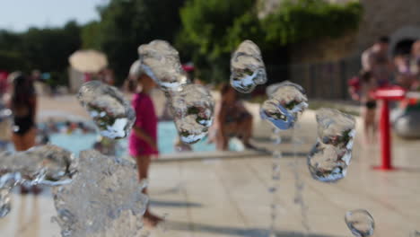 water fountain in slow motion camping, people chilling in a pool background