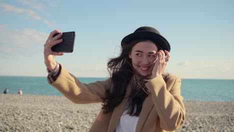 mujer tomando selfies en la playa