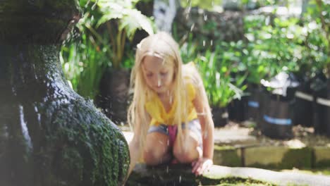 little girl next to a fountain in a nature